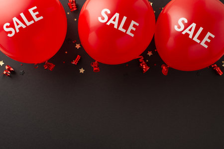 Get ready for Black Friday bargains! Top view photo featuring "sale" balloons, serpentine, and star-shaped confetti against a black backdropの写真素材