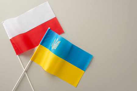 Bridging borders: A top view visual representation of Ukraine and Poland's partnership, showcasing their national flags on a soft gray canvasの写真素材