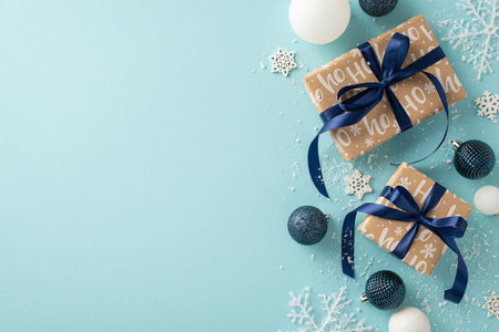 Unwrap joy hidden under the holiday tree. Top-view image featuring wrapped gift boxes, elegant baubles, snowflake embellishments, and snow on a light blue background with empty space for textの写真素材
