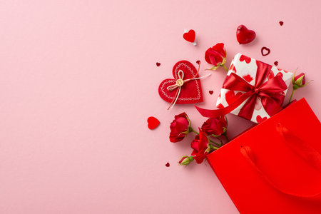 Romantic surprise awaits! Top view shot of paper bag with themed giftbox, adorned with love-patterned paper. Red roses, heart-shaped confetti on pastel pink backdrop, leaving space for sweet messageの写真素材