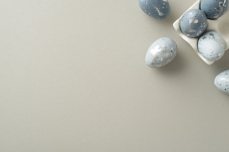 Easter setting capture: Top view of dove-grey eggs in an artisan ceramic case laid out on a pastel gray surface, with an area for textの写真素材