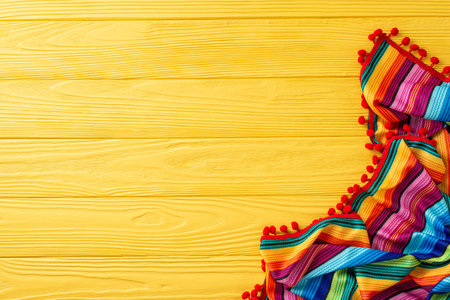 Celebrate Cinco de Mayo with this festive top view display: traditional striped serape on yellow surface. Great for themed promotionsの写真素材