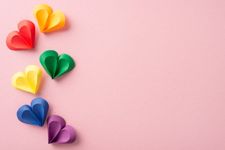 Celebration of diversity and love: Top view vibrant hearts on soft pink backdrop symbolize inclusivity. Perfect for promoting unity and support during Pride month. Social text or ad can fit seamlesslyの写真素材