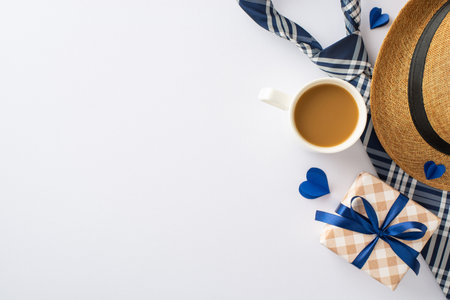 Father's Favorites: Overhead view of a straw hat, dapper necktie, gift box, cup of fresh coffee, and heart cutouts on white. Great for Father's Day wishes or advertisementsの写真素材