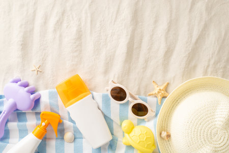 Kids' sun care essentials. Top view of SPF lotion bottles with sand play kit: rake, mold,...