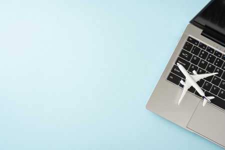 Airplane model on a laptop keyboard representing the concept of travel planning, online booking and modern technology in travelの写真素材