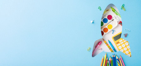Colorful back to school supplies arranged in the shape of a rocket, symbolizing creativity and...