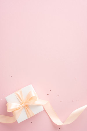 White vertical gift box with a bow on a pink background. Perfect for celebrations, birthdays, and special occasionsの写真素材
