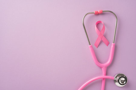 Pink stethoscope and pink ribbon symbolizing breast cancer awareness on a soft pink background, representing health care and supportの写真素材