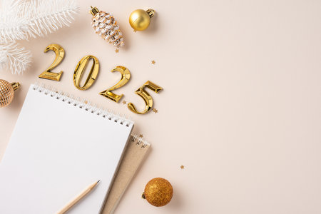 A blank notebook with a pencil placed alongside golden 2025 decorations and ornaments, symbolizing new year resolutions and planningの写真素材