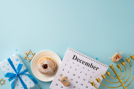 A Hanukkah-themed scene with a menorah, dreidel, sufganiyah, and festive decorations on a light blue background, featuring a December calendar and wrapped giftの写真素材