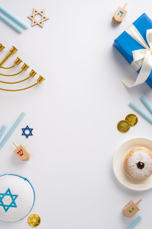 Vertical image depicting a Hanukkah celebration with traditional elements such as a menorah, dreidels, and festive treatsの写真素材