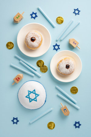 Festive Hanukkah vertical scene displaying traditional donuts, dreidels, menorah coins, and holiday symbols on a blue backgroundの写真素材