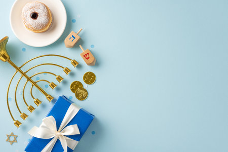 Festive Hanukkah scene with a menorah, dreidels, blue gift, gold coins, and a sweet donutの写真素材