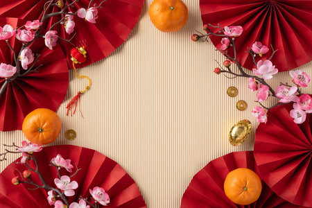 Traditional top view Chinese New Year layout featuring red paper fans, oranges, plum blossoms, and gold coins, symbolizing prosperity and good fortuneの写真素材