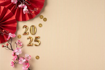 A minimalistic Chinese New Year scene featuring cherry blossoms, gold numbers for 2025, red paper fans, and gold coins on a textured pastel backgroundの写真素材
