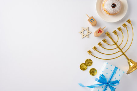 A festive Hanukkah arrangement featuring a menorah, dreidels, Star of David, coins, and a gift box, perfect for celebrating the Jewish holidayの写真素材