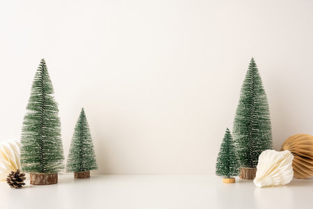 A side view serene, minimalist Christmas scene featuring snow-covered miniature trees and Scandinavian-style decor, evoking a peaceful winter holiday atmosphereの写真素材