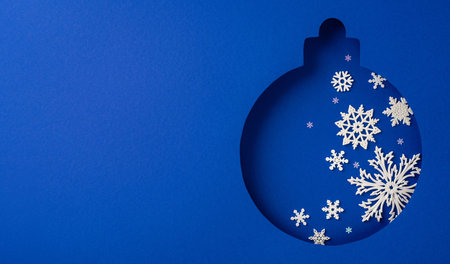 This image features a festive blue Christmas ornament cutout adorned with delicate white snowflakes, evoking a sense of winter wonder and holiday spiritの写真素材