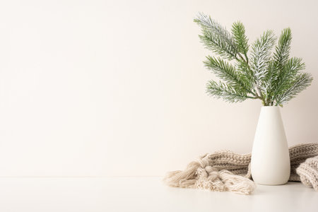 A side view simple, elegant Scandinavian-inspired winter scene featuring pine branches in a white vase. The soft, neutral colors create a cozy atmosphere, perfect for holiday or Christmas decorationsの写真素材
