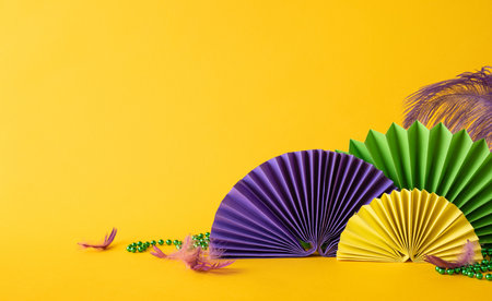 Vibrant side view paper fans in Mardi Gras colors with colorful beads and decorative feathersの写真素材