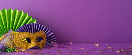 Festive Mardi Gras side view scene featuring a vibrant mask, colorful feathers, and decoration elements arranged elegantlyの写真素材