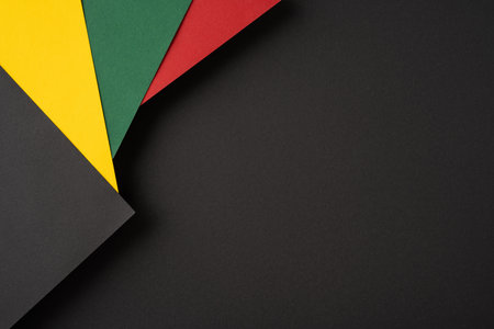 Abstract arrangement of vibrant colored papers against a black backdrop, ideal for designsの写真素材