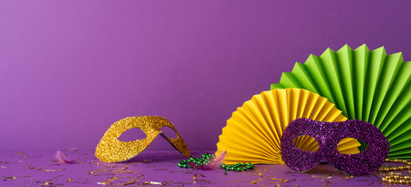 Mardi Gras side view themed accessories including glitter masks and festive decorations on purple backgroundの写真素材
