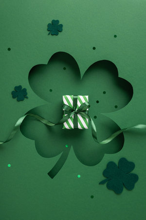 A vertical green-themed Saint Patrick's Day design featuring a clover motif and a small wrapped present, symbolizing celebration and festive spiritの写真素材