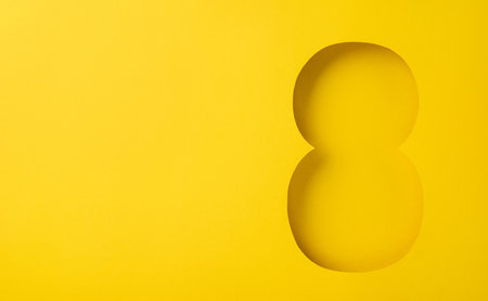 Illustration of a large number eight cut out within a monochromatic yellow background