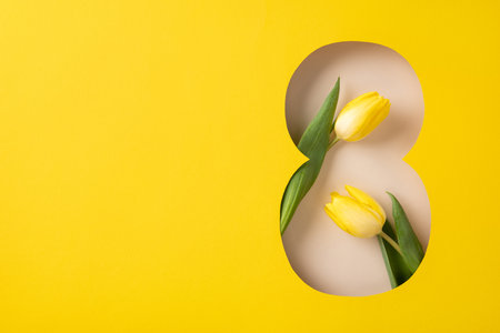 Yellow tulip flowers arranged in a figure eight cutout showcasing a modern floral designの写真素材