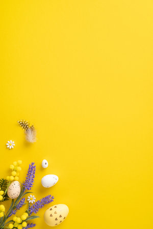 Easter-themed vertical composition with painted eggs, flowers, and decorative elements on vibrant yellow backgroundの写真素材