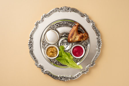 Passover Seder plate featuring symbolic items including a shank bone, lettuce, egg, and condiments. Perfect representation of the Jewish holiday Passover and its traditional symbolismの写真素材