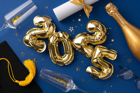 Golden 2025 balloons surrounded by graduation and celebration themed objects on a blue backgroundの写真素材