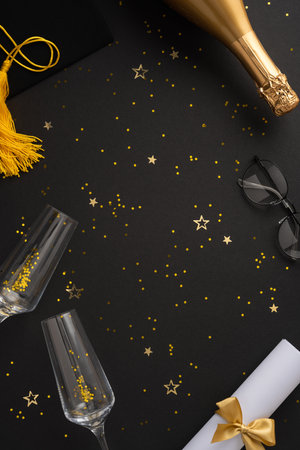 Stylish vertical arrangement of graduation items, celebratory decorations, champagne, and glasses for an eventful graduation celebrationの写真素材