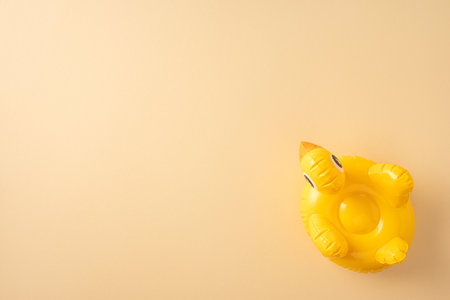 Bright yellow inflatable duck float against a tan background, representing summer and relaxation