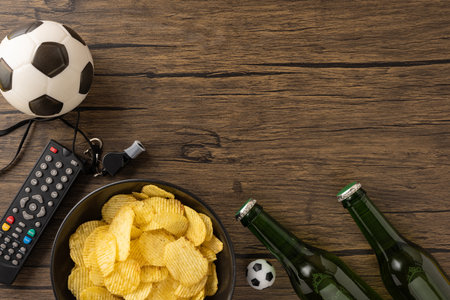 Items on a wooden surface represent a cozy football game watch at homeの写真素材