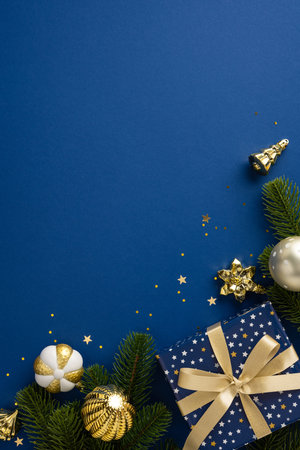 Christmas vertical themed arrangement featuring a blue background adorned with golden ornaments and gift boxes. Perfect for holiday celebrations, designs, and festive moodの写真素材