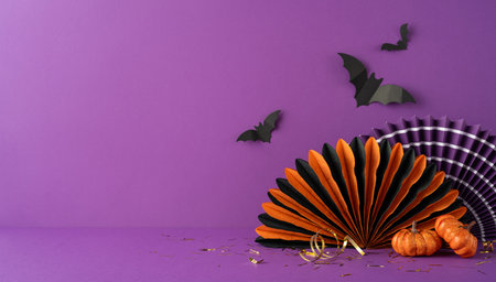 Vibrant purple side view background featuring Halloween decor including miniature pumpkins, bats, and paper decorations. Ideal for seasonal themes, celebrations, and spooky designsの写真素材