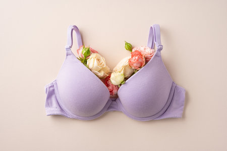 A lavender bra adorned with colorful flowers representing femininity and self-expression placed on a neutral backgroundの写真素材