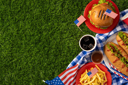 Labor Day and Independence Day celebration with American food, including hamburgers, hot dogs, fries, and flags, on a picnic setting representing patriotismの写真素材