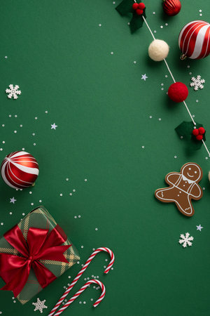 A vertical Christmas and New Year scene featuring candy canes, gifts, ornaments, a gingerbread man, and festive decorations on a green backgroundの写真素材