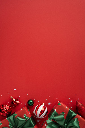 Vibrant vertical red backdrop with wrapped gifts, ribbons, and ornaments evokes Christmas and New Year cheer, perfect for holiday campaigns, greetings, and festive promotionsの写真素材