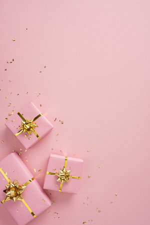 Pink vertical gift boxes with gold ribbons create a festive, elegant scene perfect for Christmas and New Year celebrationの写真素材