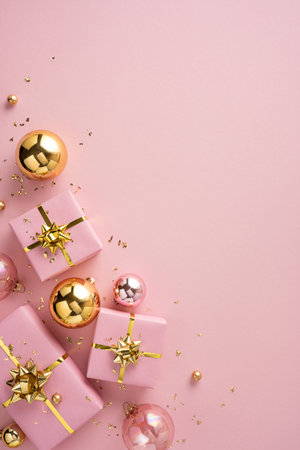 Delicate vertical pink gifts with gold ribbons and spherical ornaments create a festive holiday scene perfect for Christmas and New Year greetings and celebrationsの写真素材