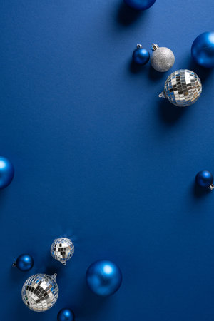 Vertical composition featuring blue ornaments and silver disco balls on a rich blue backdrop, evoking festive Christmas and New Year mood for holiday dÃ©cor, greetings and seasonal campaignsの写真素材