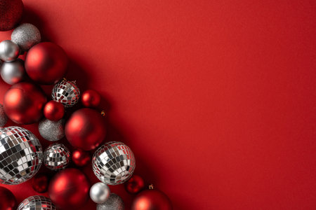 Bright red backdrop with silver disco balls and red ornaments creates a festive holiday mood, perfect for Christmas and New Year themes. Ideal for greeting cards, banners, and seasonal promotionsの写真素材