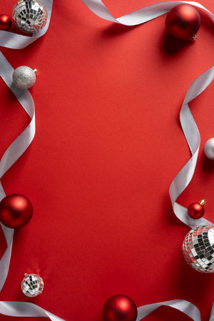 Vertical display with red backdrop, silver ribbon, and glittering ornaments for Christmas and New Year celebration and greetingの写真素材