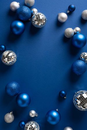 Vertical arrangement of blue Christmas ornaments and silver discoball accents creates a festive holiday scene, ideal for Christmas and New Year greeting, winter decor and celebration imageryの写真素材