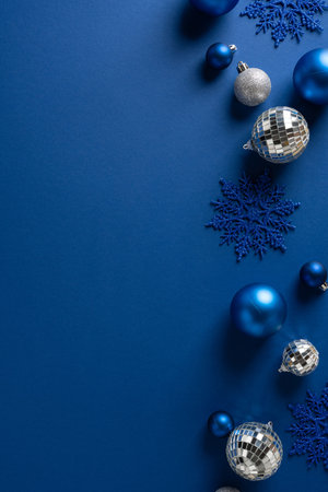 Vertical blue holiday scene with ornaments, snowflakes and disco ball accents, conveying festive mood and winter celebration for Christmas and New Year greetingsの写真素材